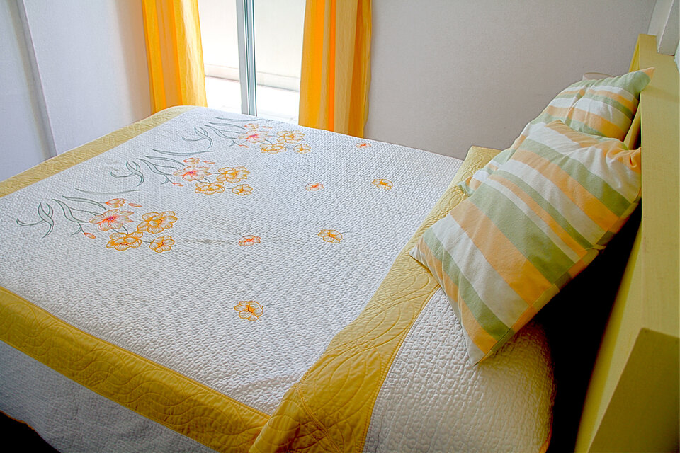 Detalle de la ropa de cama con la luz de la mañana entrando de costado