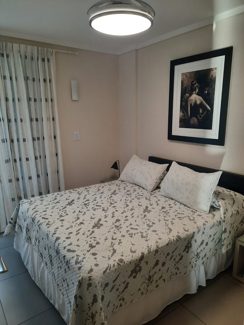 Ropa de cama clara con estampa gris, bajo la luz de la tarde