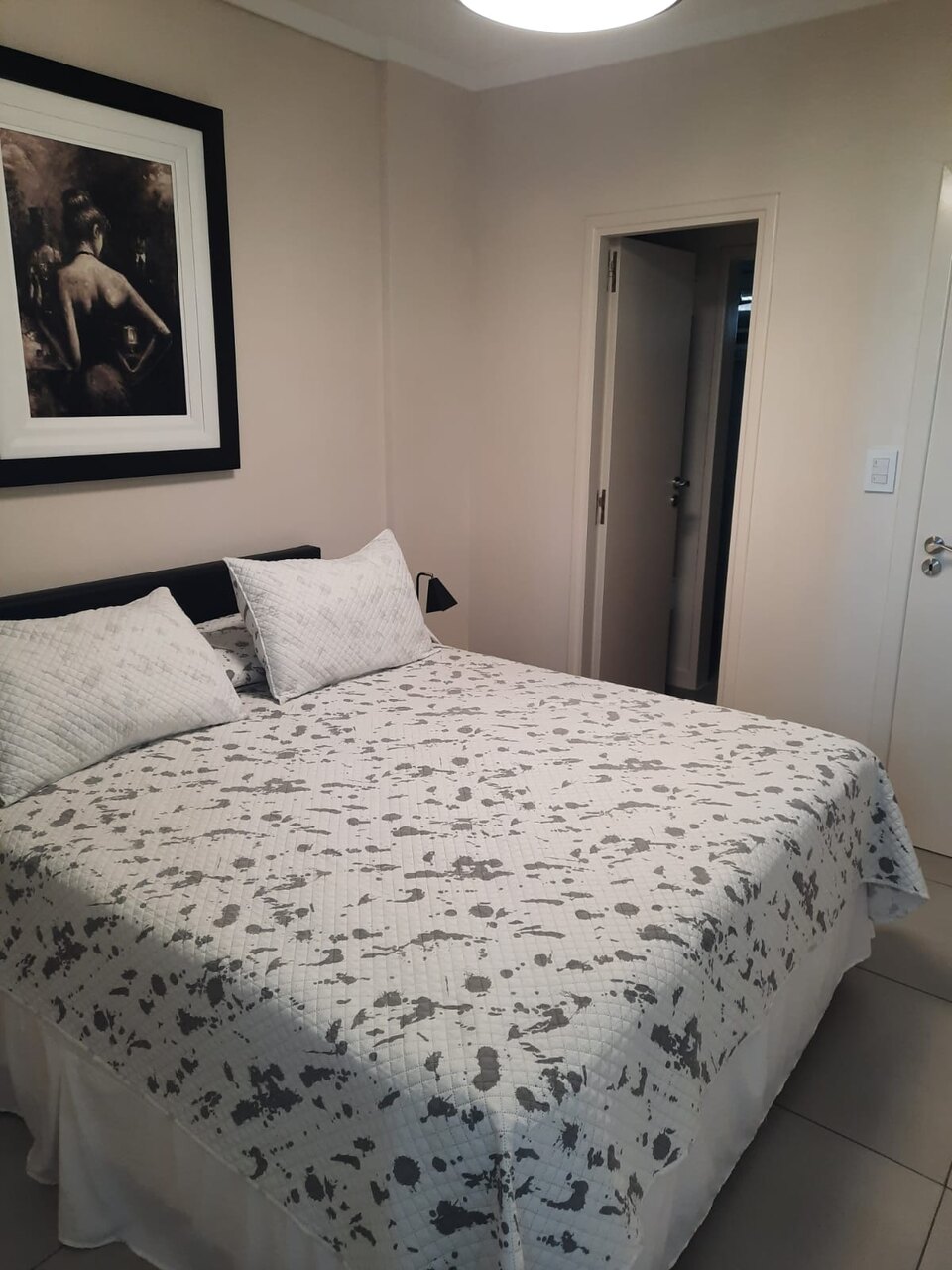 Dormitorio en suite con cabecera capitoné y el paso al baño propio