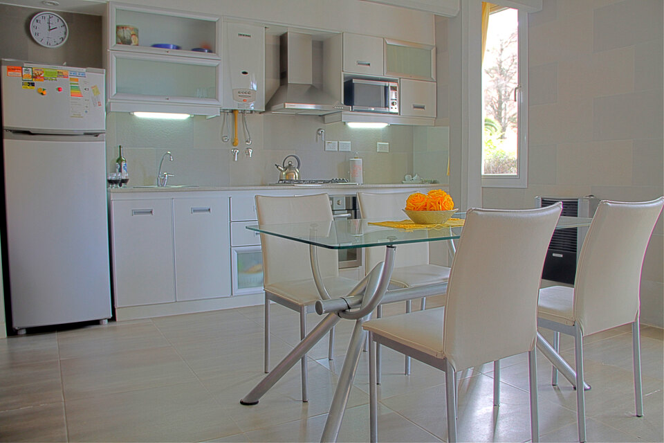 Cocina y comedor resueltos como una sola pieza continua, con la luz clara del mediodía